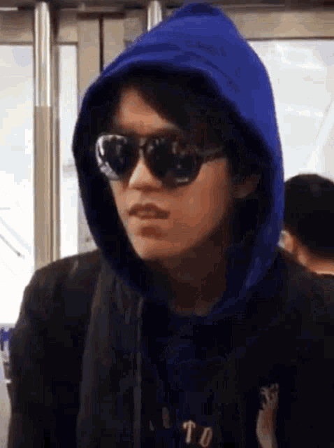 a man wearing sunglasses and a blue hoodie