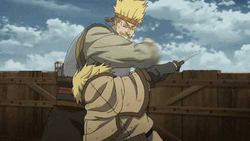a man is holding another man 's arm while holding a knife in his hand