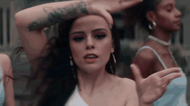 a woman with a tattoo on her arm is dancing in front of other women