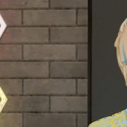 a close up of a person 's head with a brick wall in the background