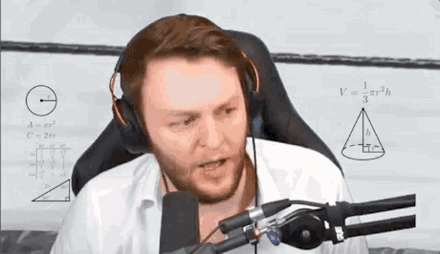 a man wearing headphones and a microphone is sitting in front of a white board with math equations on it .