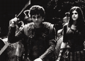 a black and white photo of a man and a woman standing next to each other in a crowd .