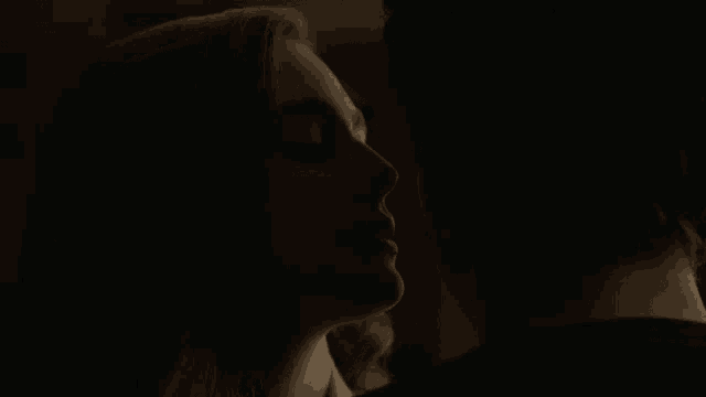 a man and a woman are kissing in the dark .