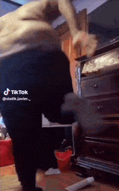 a man is standing in front of a dresser with a tiktok watermark on the bottom right corner
