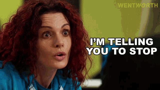 a woman with red hair is telling someone to stop