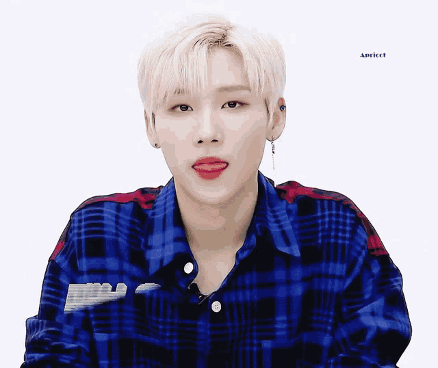 a young man wearing a blue plaid shirt is sticking out his tongue and the word apricot is above him