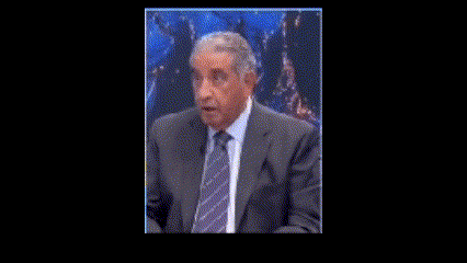 a man in a suit and tie is talking on a television show