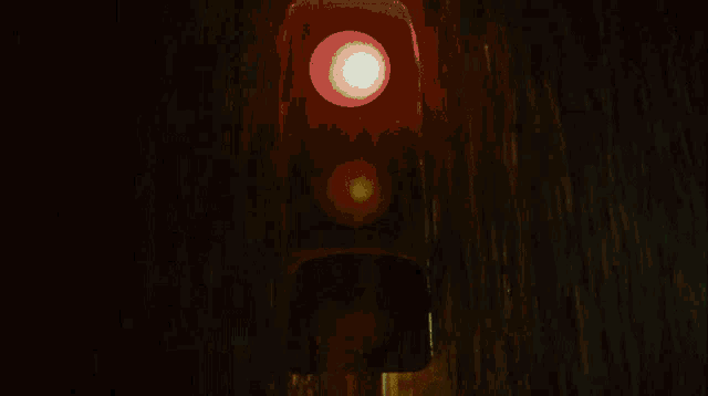 a traffic light in the rain with a red light and a yellow light