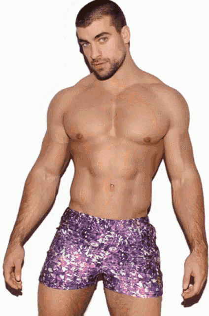 a shirtless man is wearing purple shorts with a pattern
