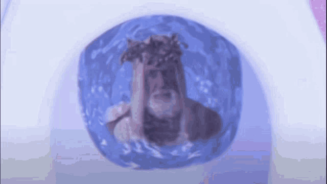 a man with a crown of thorns on his head is swimming in a pool of water .