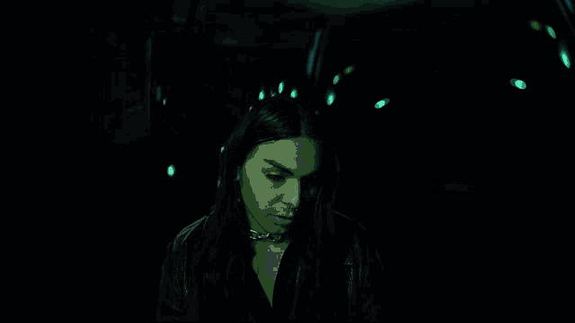 a woman in a dark room with a sign that says ' i love you ' on it