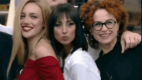 a group of three women are posing for a picture together .