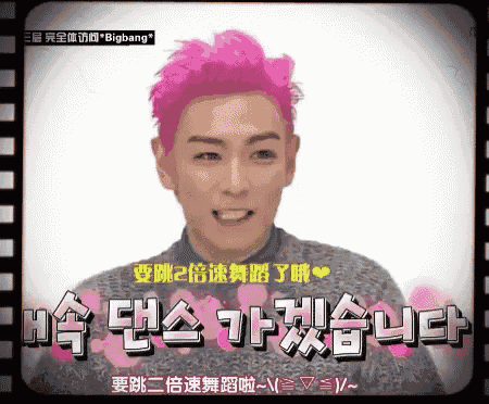 a man with pink hair is smiling and says bigbang in a foreign language