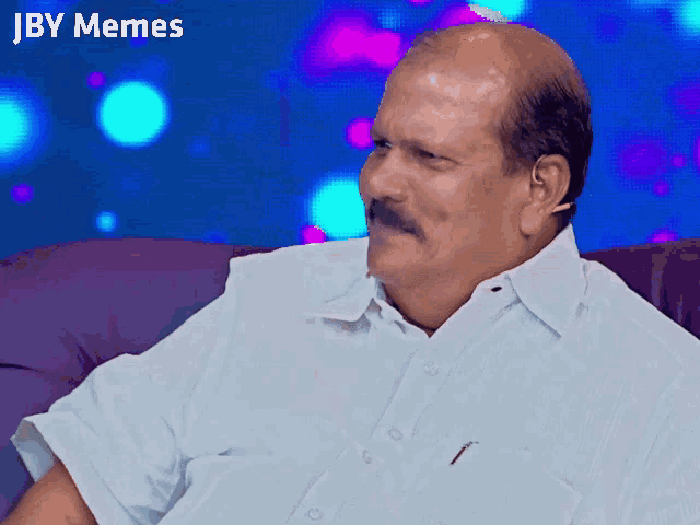 a bald man with a mustache is sitting on a couch with jby memes written on the bottom