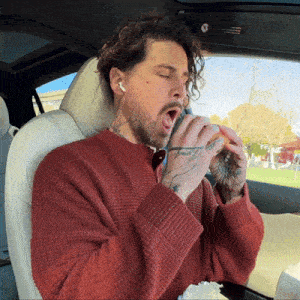 a man in a car with a tattoo on his arm that says ' freedom '