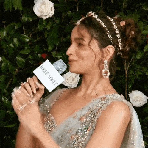 a woman holding a microphone that says vogue