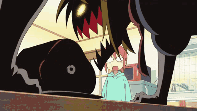 a girl in a blue hoodie is looking at a monster