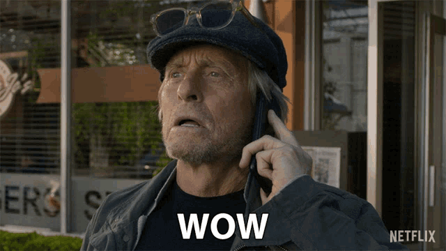 a man is talking on a cell phone and the word wow is on the screen