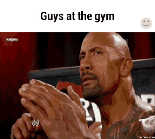 a man is clapping his hands in front of a microphone with the words guys at the gym written below him .