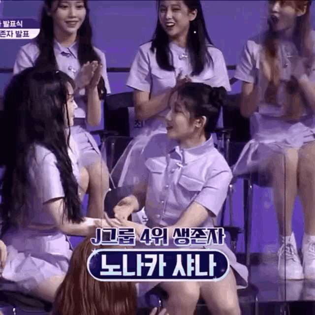 a group of girls are sitting in chairs and one of them is holding another girl 's hand