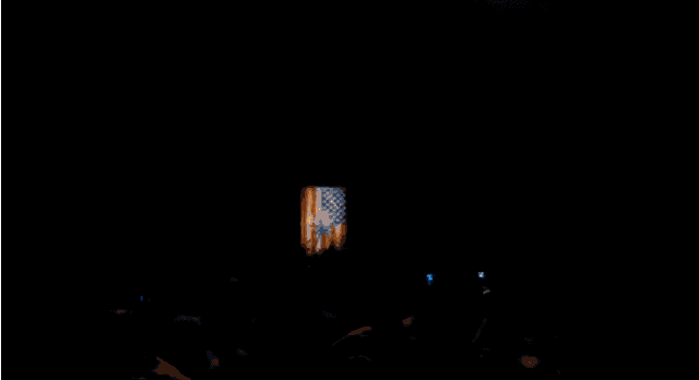 a crowd of people standing in front of a stage