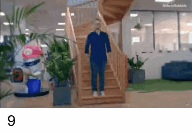 a man is walking up a set of wooden stairs in a building .