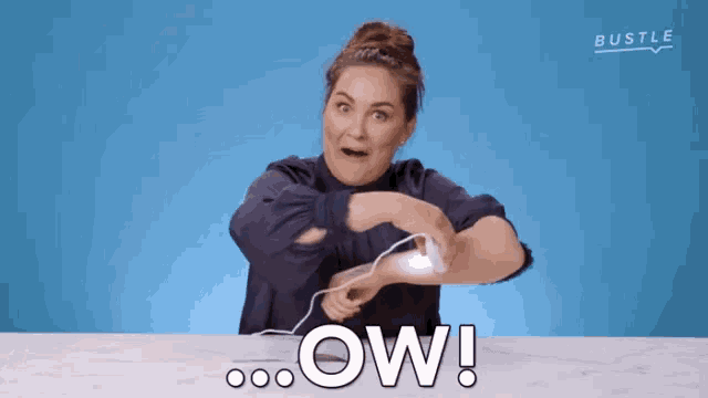 a woman sitting at a table with the word ow written on it