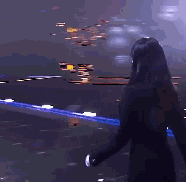 a woman in a black suit is standing in front of a screen
