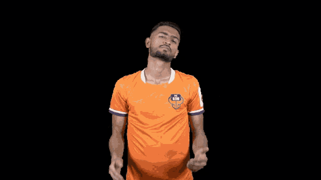 a man wearing an orange shirt with the word goa on the front