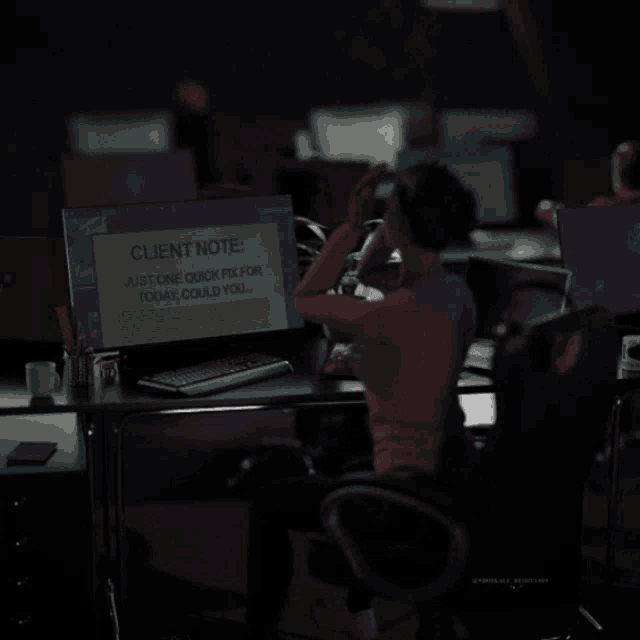 a person sitting at a desk with a client note on the screen