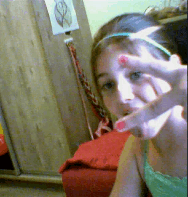 a girl with red nail polish is making a selfie