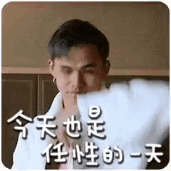 a man in a white robe is sitting on a bed and holding a piece of paper in his hand .