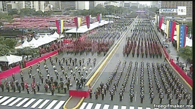 a large group of people marching down a street with a sign that says caracas