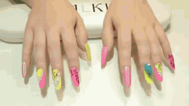 a woman 's nails are painted in different colors and the word milky is on the white surface