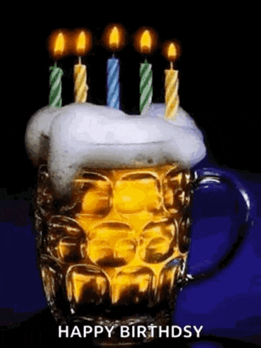 a beer mug with candles on top of it and the words `` happy birthday '' .
