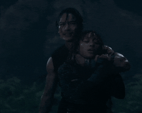 a man carrying a woman in his arms in the dark