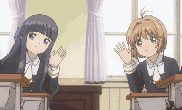 two anime girls sitting at desks waving their hands in a classroom