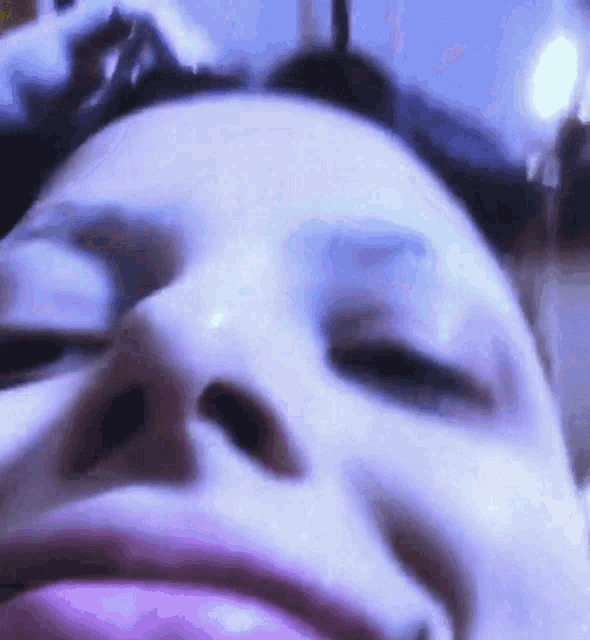 a close up of a woman 's face with purple eyeshadow