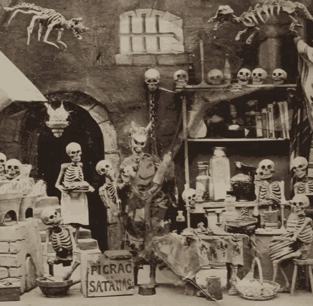 a display of skeletons and skulls with a sign that says picrac satanas