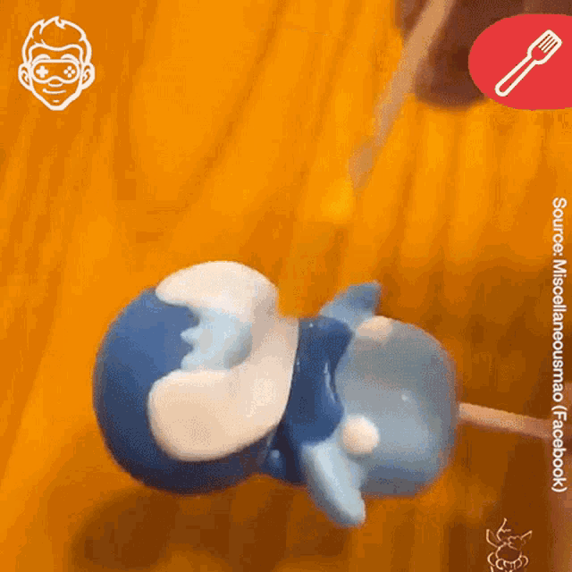 a person is decorating a blue and white toy with icing