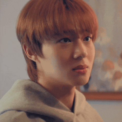 a close up of a young man 's face with a hoodie on
