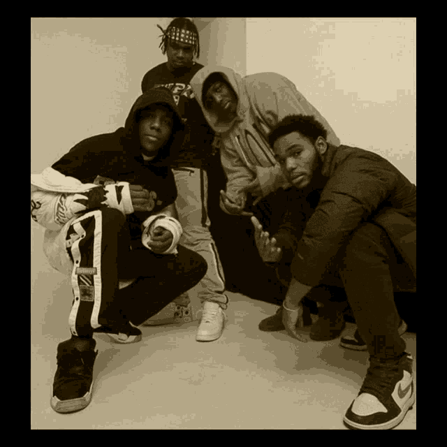 a group of young men posing for a picture with one wearing a shirt that says ' a.p.c. '