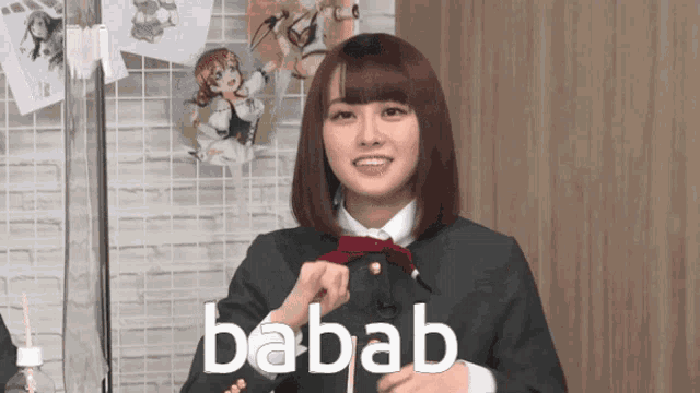 a girl in a suit says babab in front of a wall of anime pictures