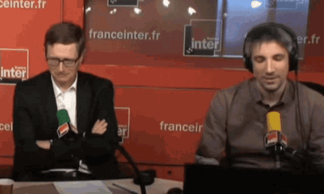 two men are sitting in front of microphones in front of a franceinter.fr sign