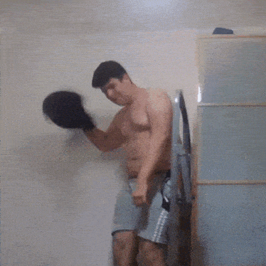 a shirtless man is standing on a staircase holding a black shirt