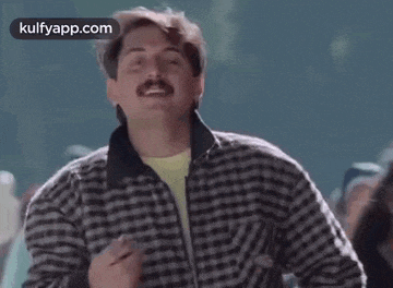 a man with a mustache is wearing a plaid jacket and dancing .