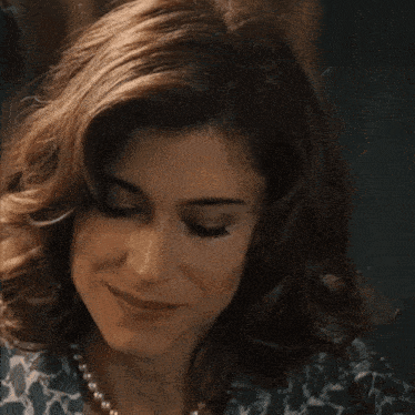 a close up of a woman 's face with a pearl necklace