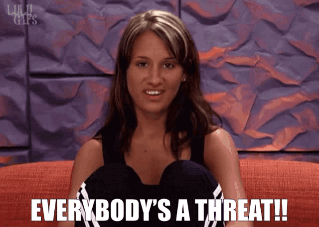 a woman is sitting on a couch with the words everybody 's a threat