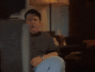 a man sitting in a chair with the words there 's boobies on my tv below him