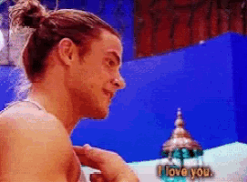 a man with a bun on his head says i love you in a pixelated image